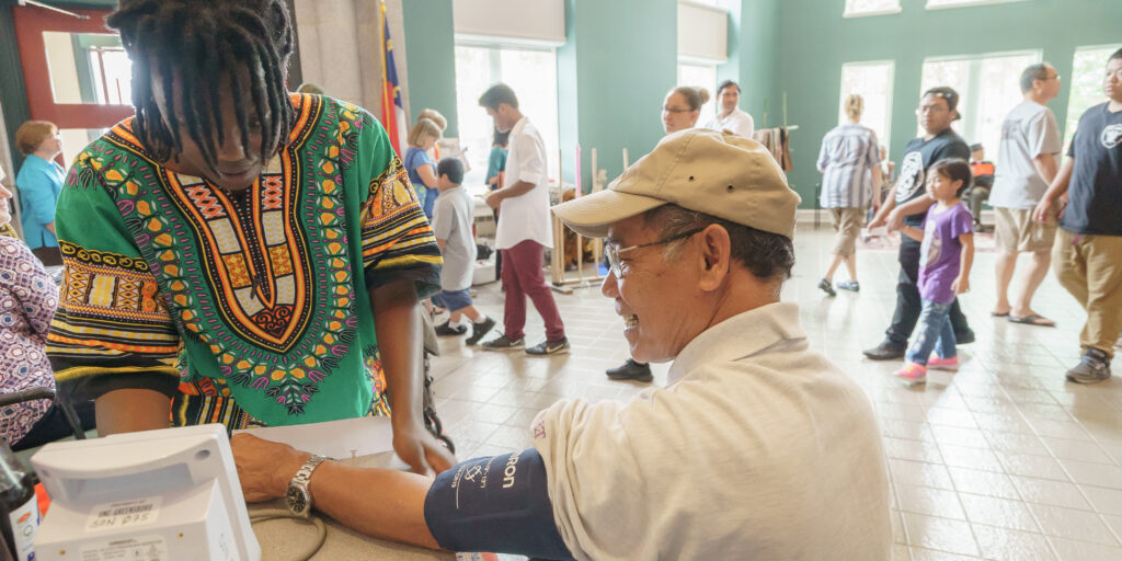A researcher measuring the blood pressure of a participant in the Montagnard Outreach program.