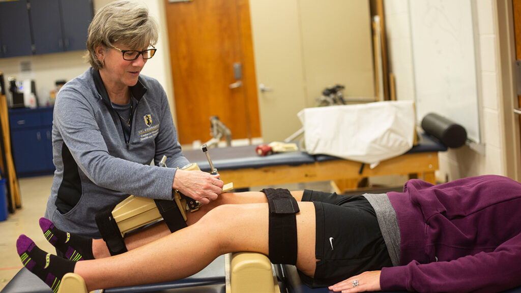 Dr. Sandra Shultz taking measurements of a participant's knee.