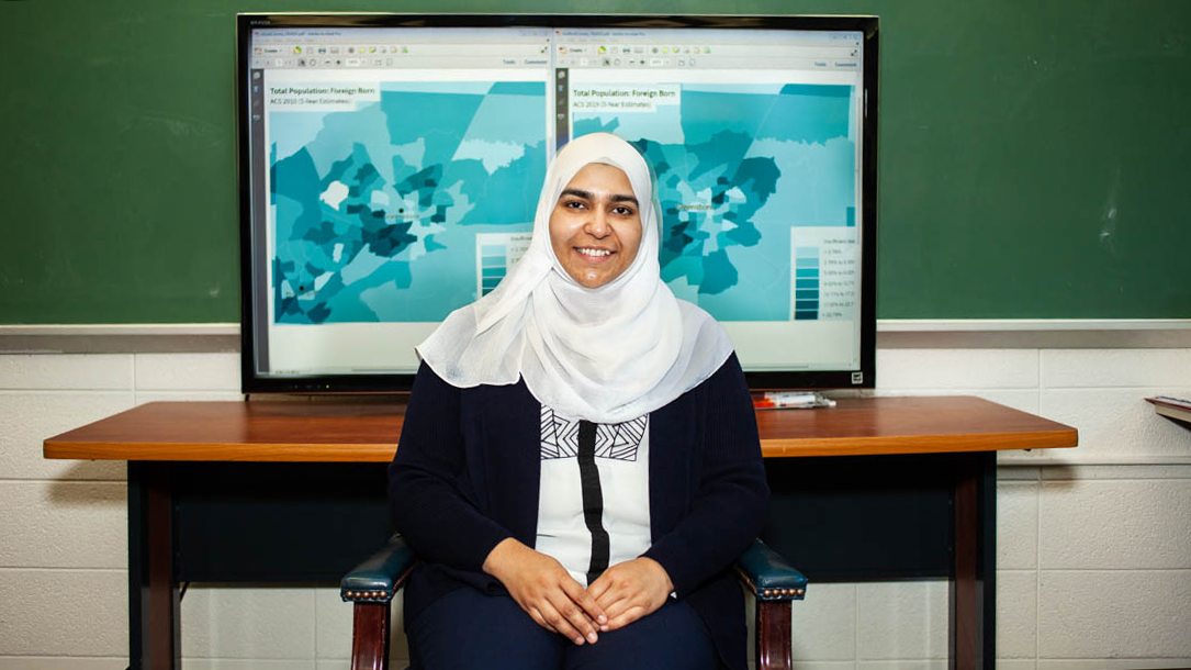 Nabeela Farhat sits in front of a map she created.