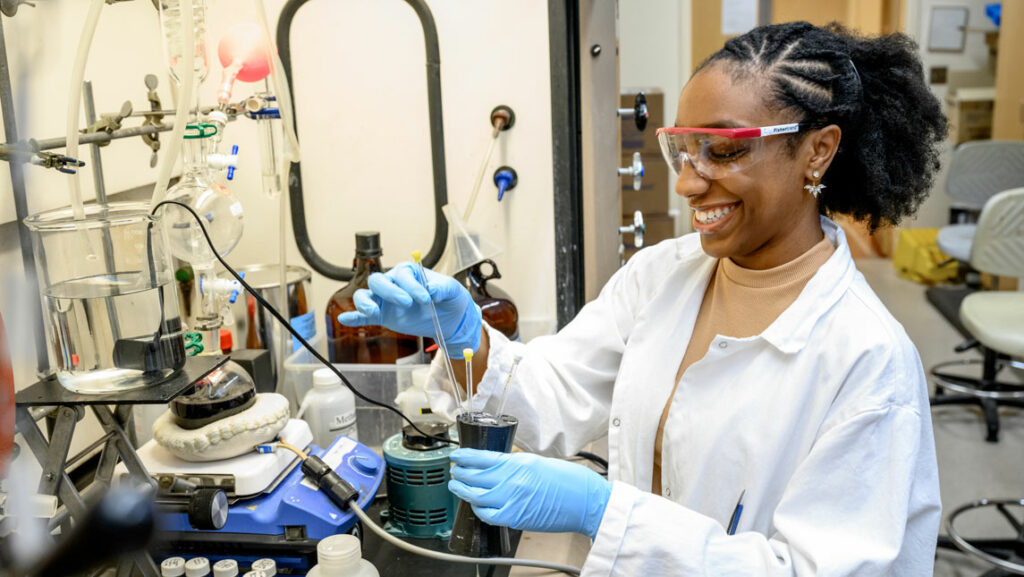 Masters student Tangela Johnson rearranges lab tools at a work bench.