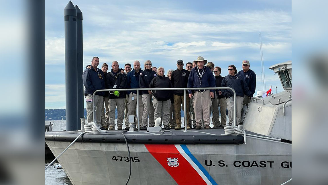 A medical squad stands on the bow of a Coast Guard ship.
