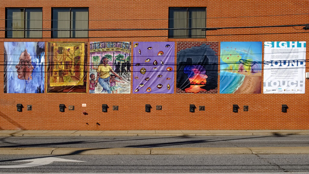 Brick wall on the side of a building with different tapestry designs