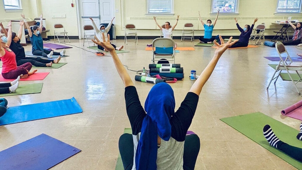 multiple women practicing yoga inside of a studio