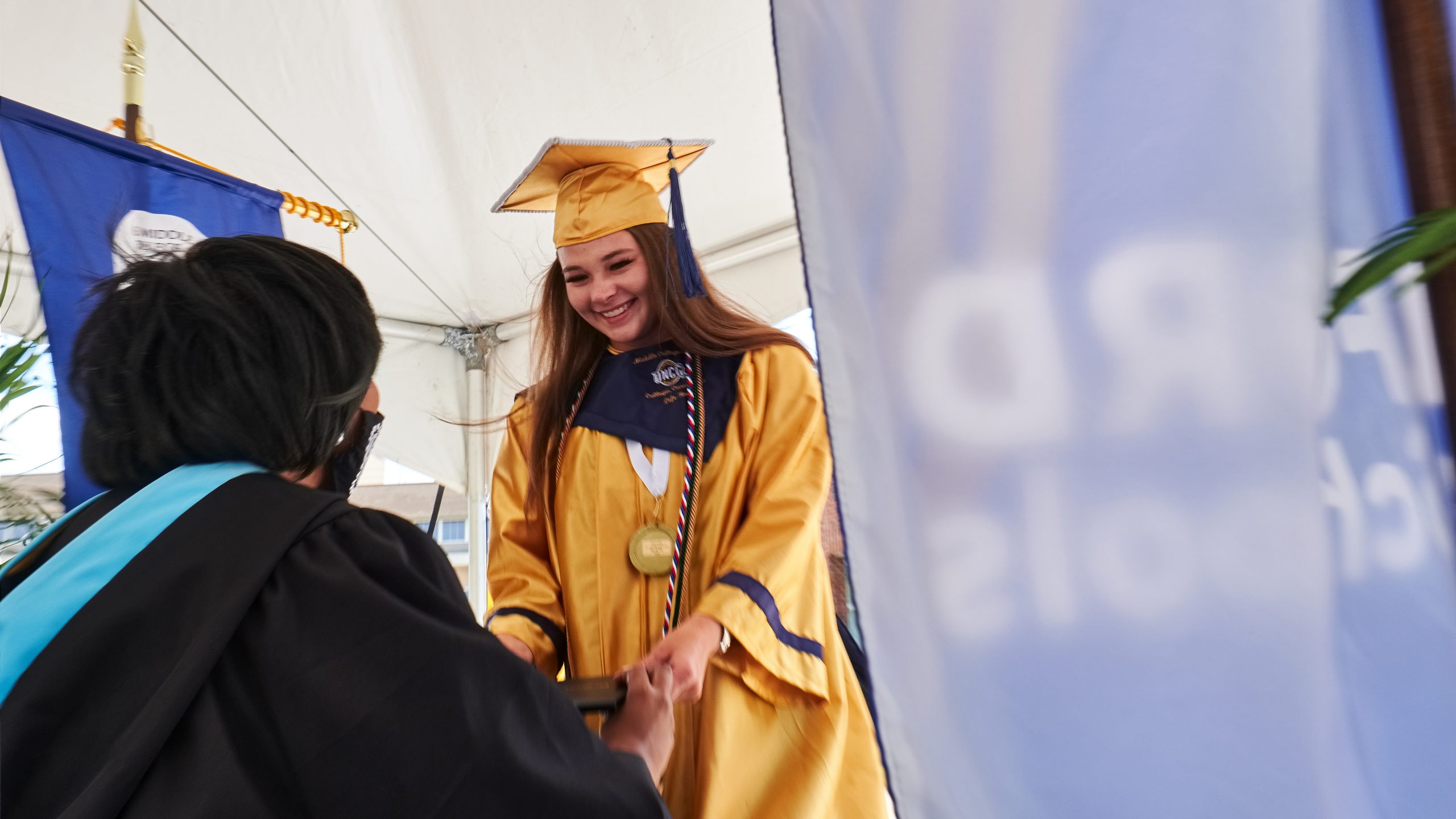 UNCG Middle College graduation in 2020 – girl receives diploma