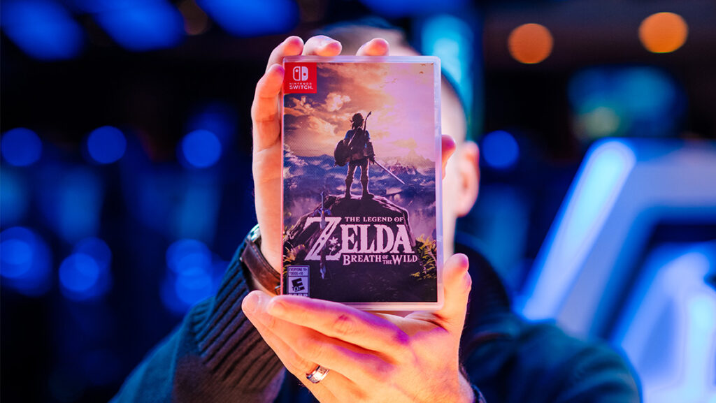 A student holds a copy of "The Legend of Zelda: breath of the Wild"