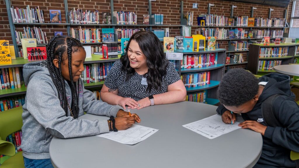 Graduate student Grace Finn tutoring two students