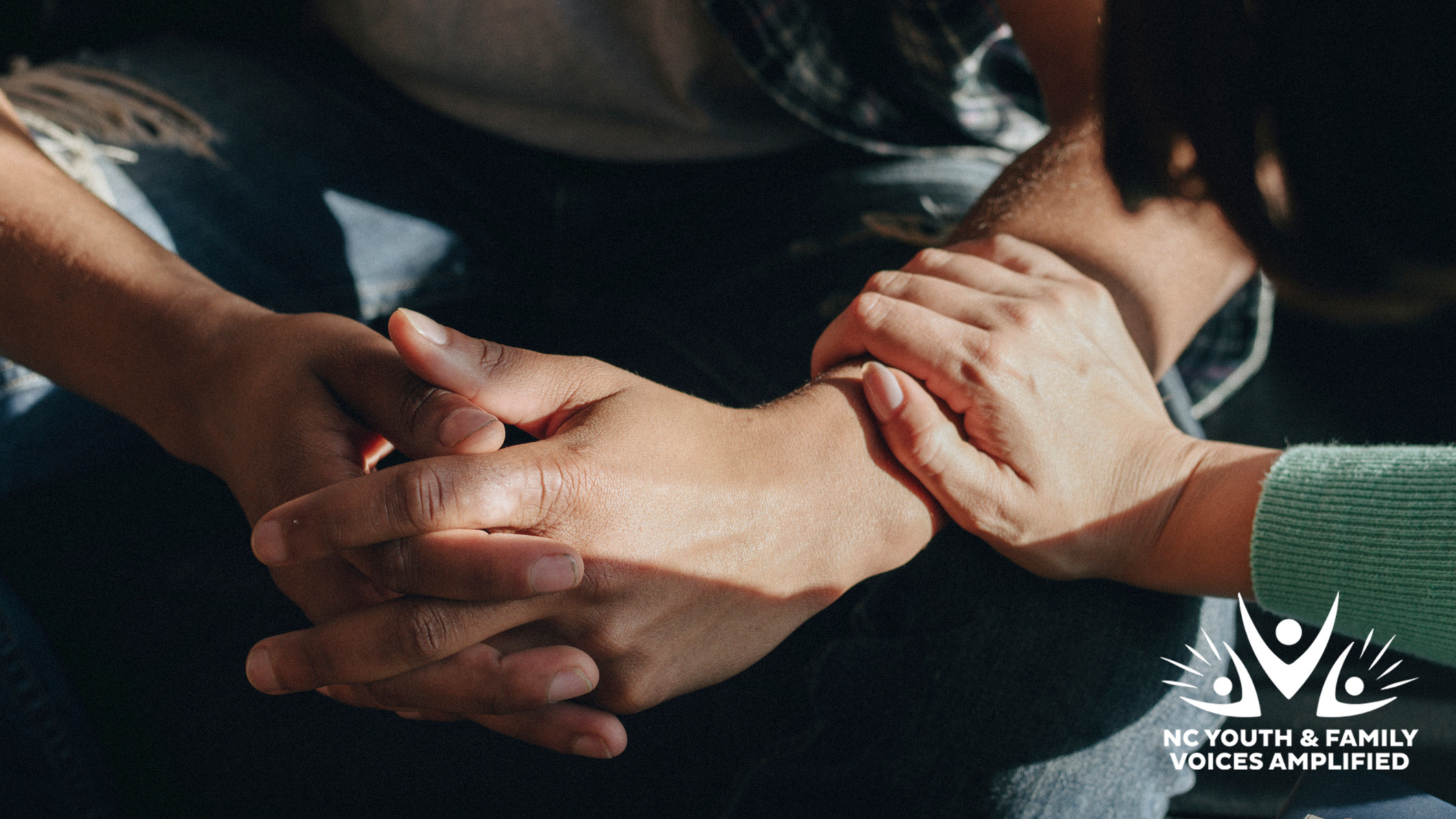 People support each other in a rehab session with the NC Youth and Family Voices Amplified logo in the bottom right corner