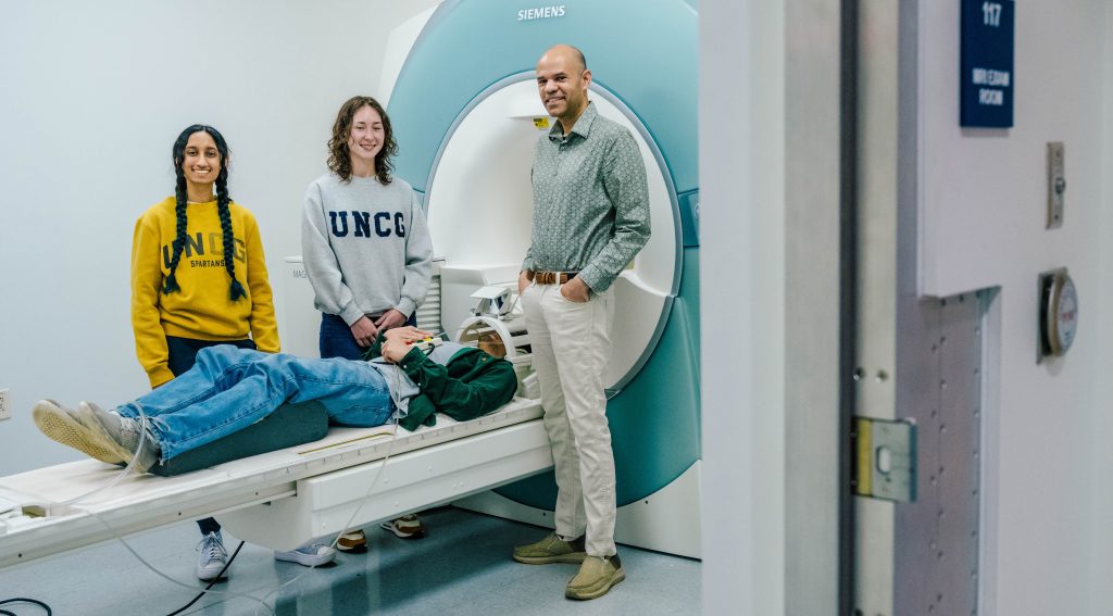 Dr. Robert Wiley stands with his undergraduate mentees near UNCG's MRI machine