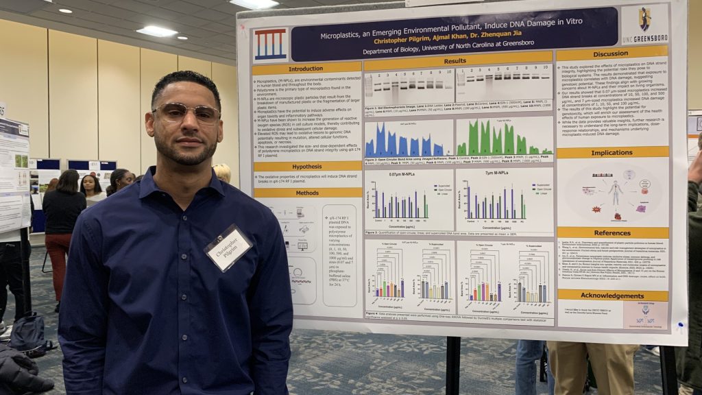 Christopher Pilgrim stands with his poster at the URSCO expo