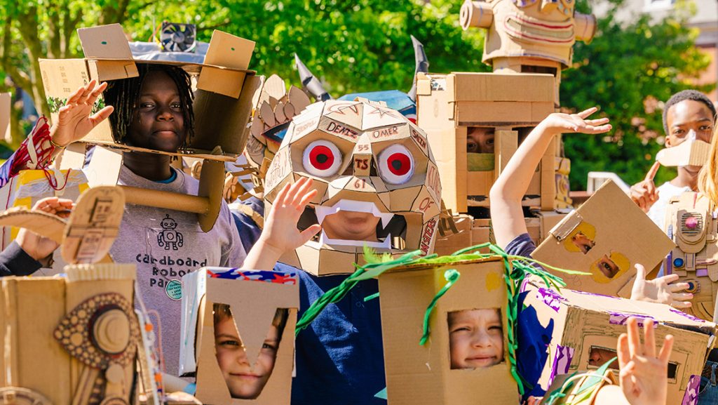 Kids wear their cardboard robots outfits in the parade