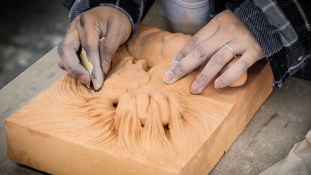 Hands shaping clay