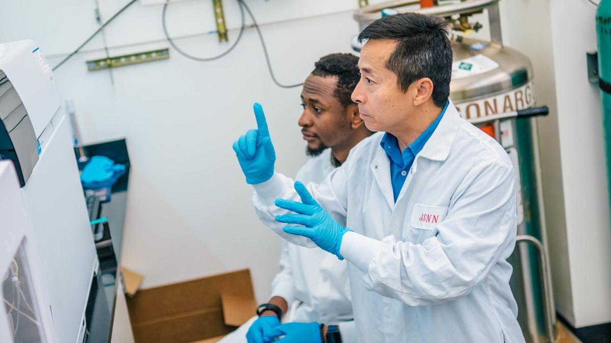 Dr. Jianjun Wei does an experiment with one of his grad students