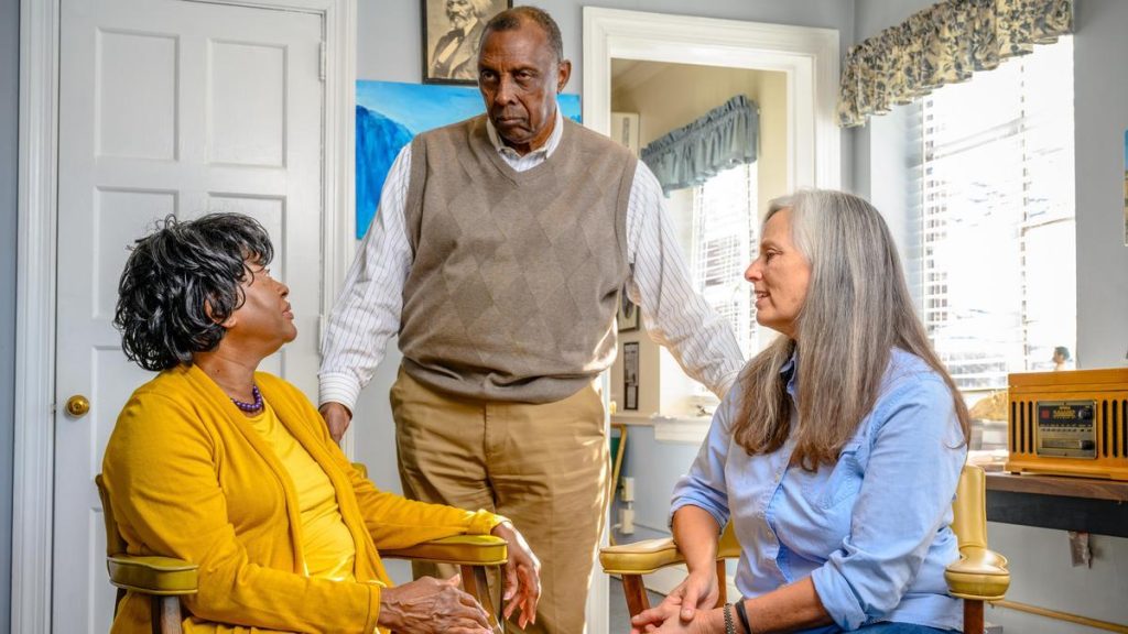 A professor speaks to two older adults