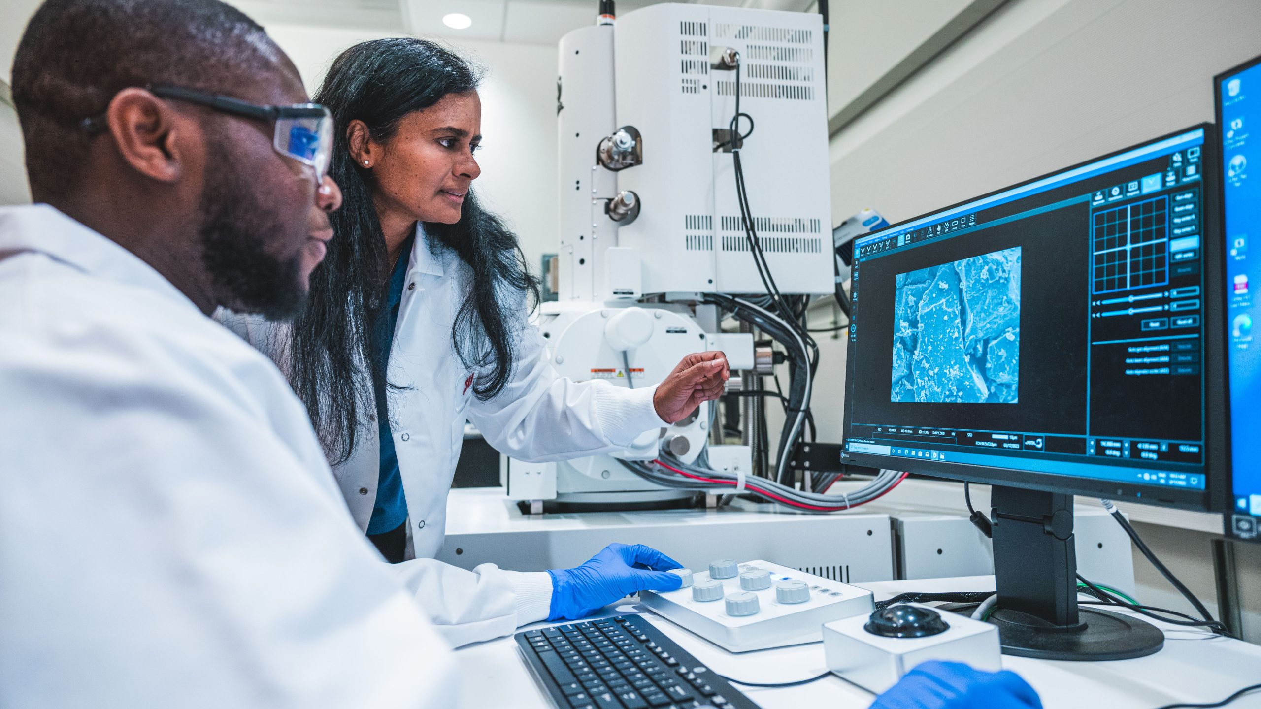 UNCG nanoscience researcher Dr. Hemali Rathnayake and graduate student Kelvin Aldrah examine an electron microscope image.